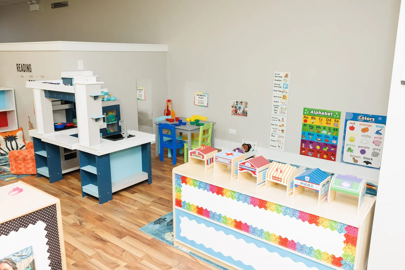 Bright classroom with learning centers and a rainbow-trimmed table