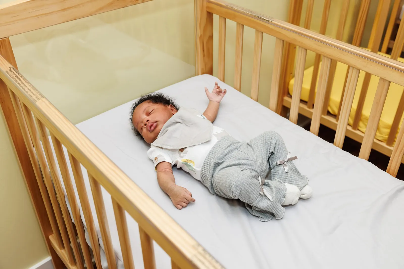 Infant resting comfortably in a wooden crib