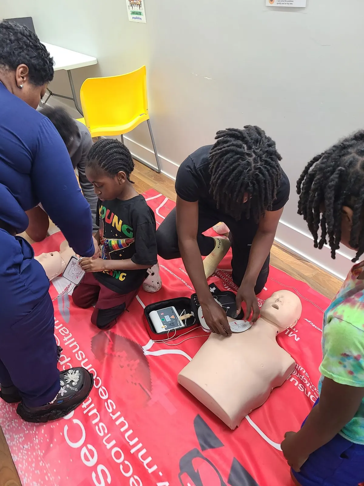 Young students practicing CPR skills during a first aid class